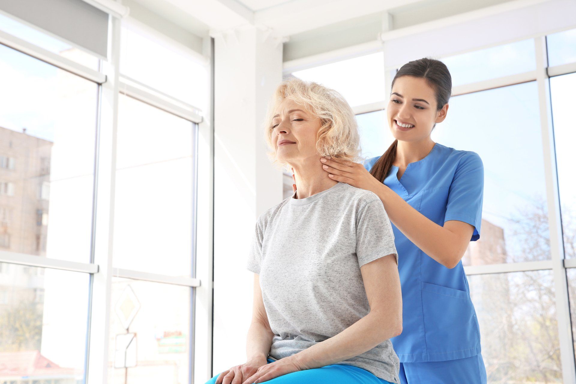 Une infirmière donne un massage à une femme âgée dans un hôpital.