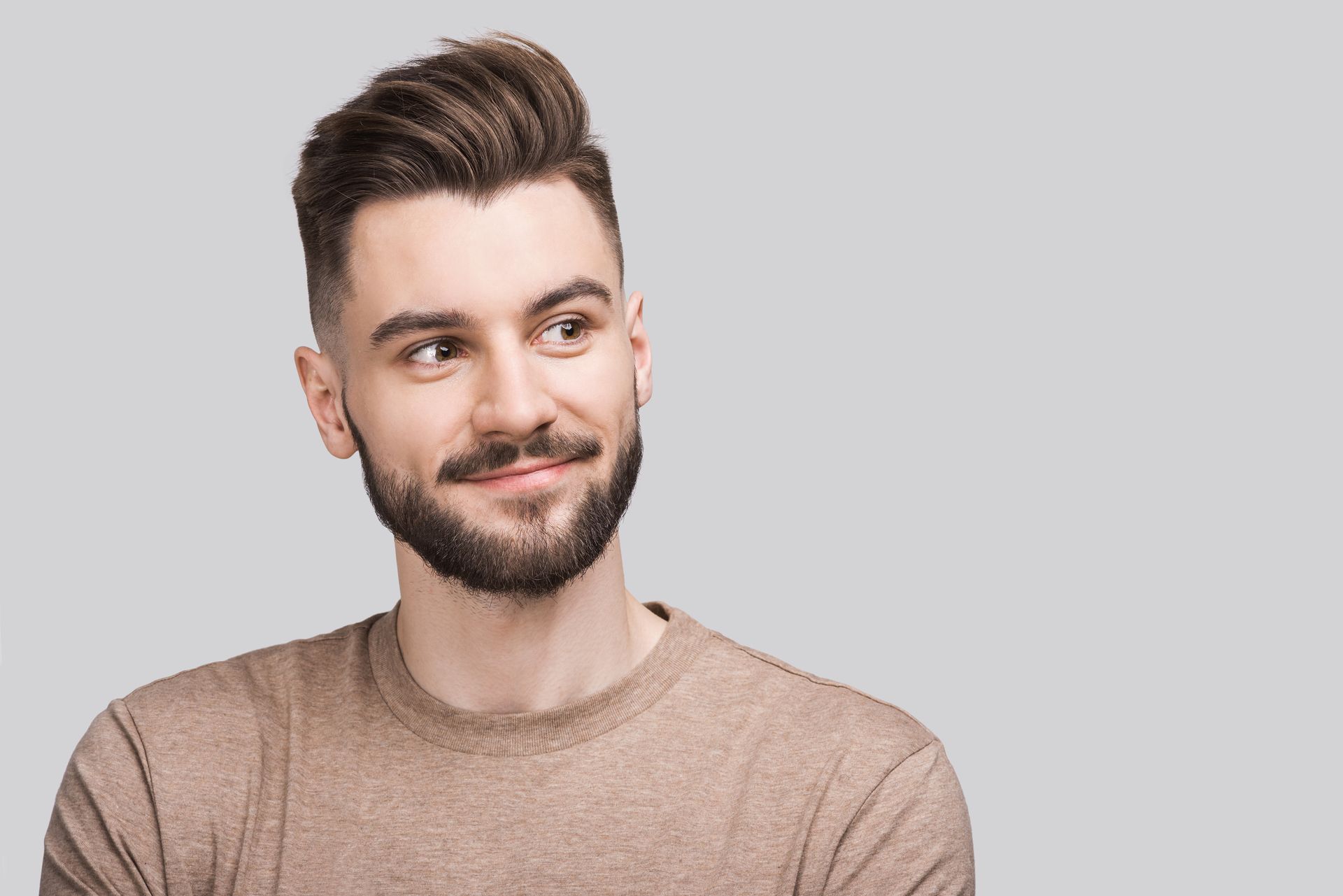 Ein Mann mit Bart lächelt und schaut nach oben.