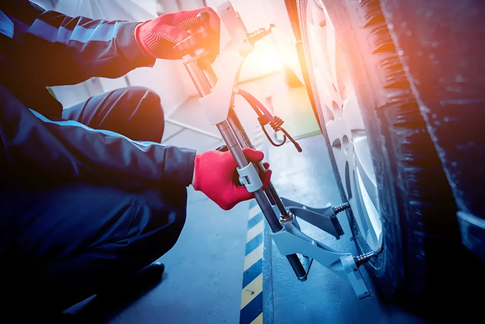 Mechanic Adjusting a Car Tire — BJM Mechanical Mufflers & Tyres in Oxenford, QLD