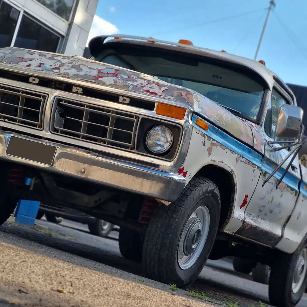 A Weathered White Ford Pickup Truck Parked Outside
