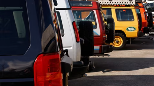 Line of Land Rover vehicles parked side by side, including a Land Rover-branded model