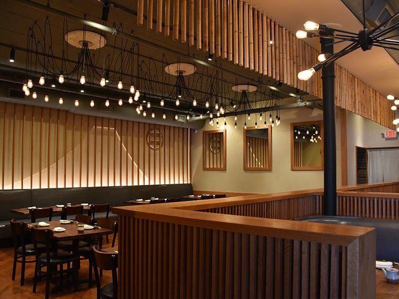 A restaurant with tables and chairs and a wooden ceiling