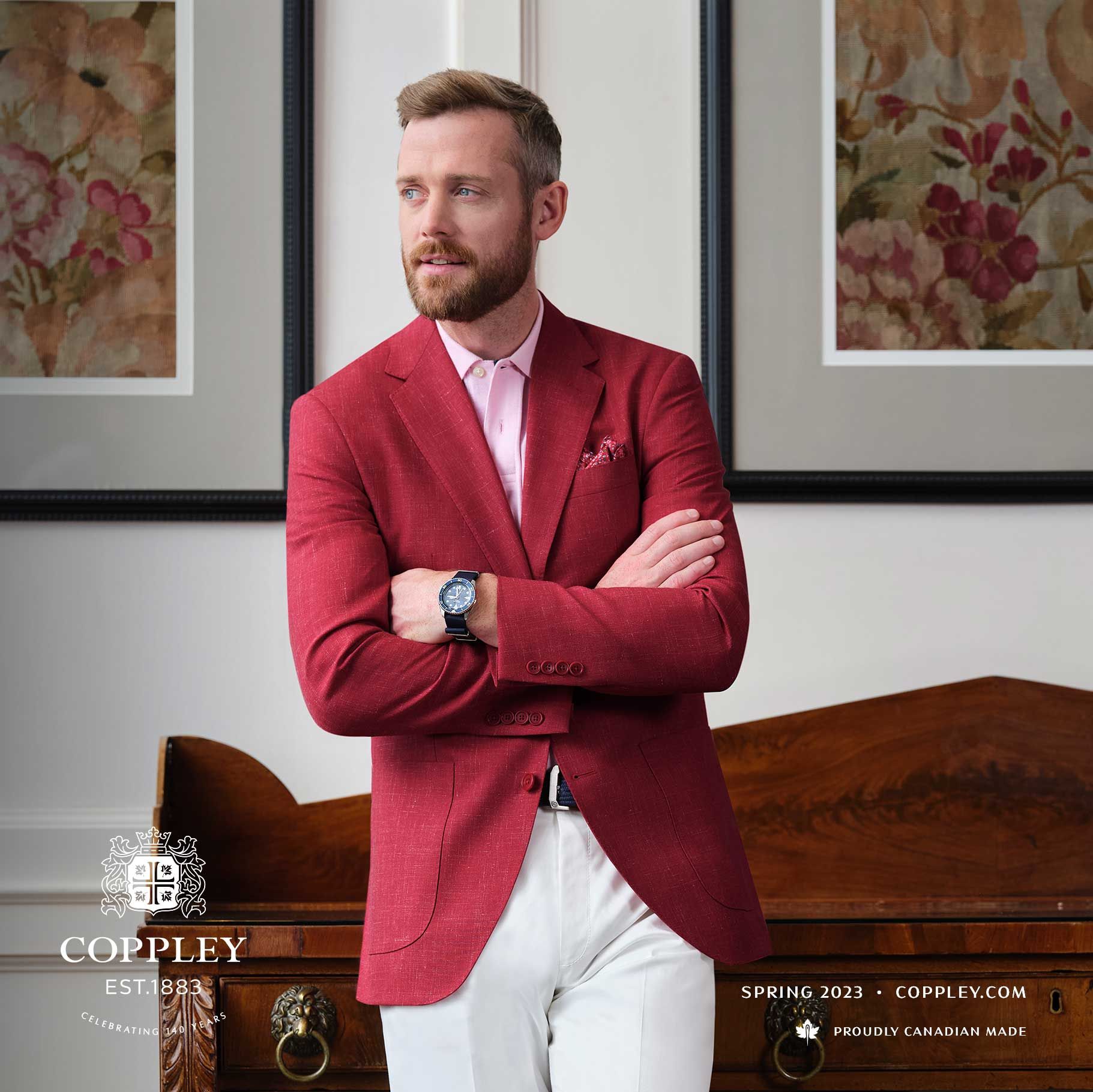 A man is wearing a red jacket and white pants