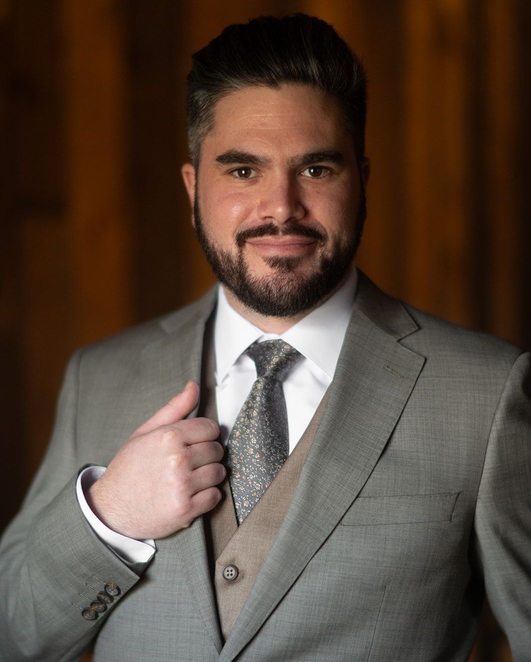 A man with a beard is wearing a suit and tie