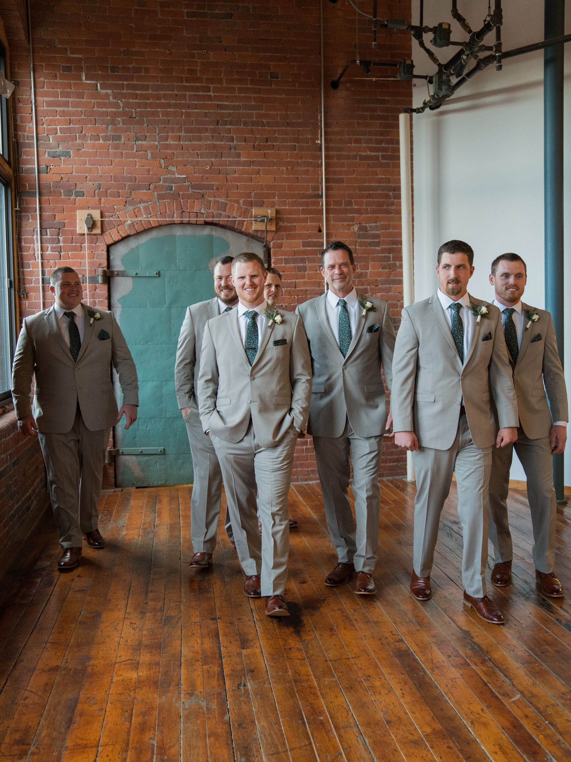 A group of men in suits and ties are standing next to each other in a room.