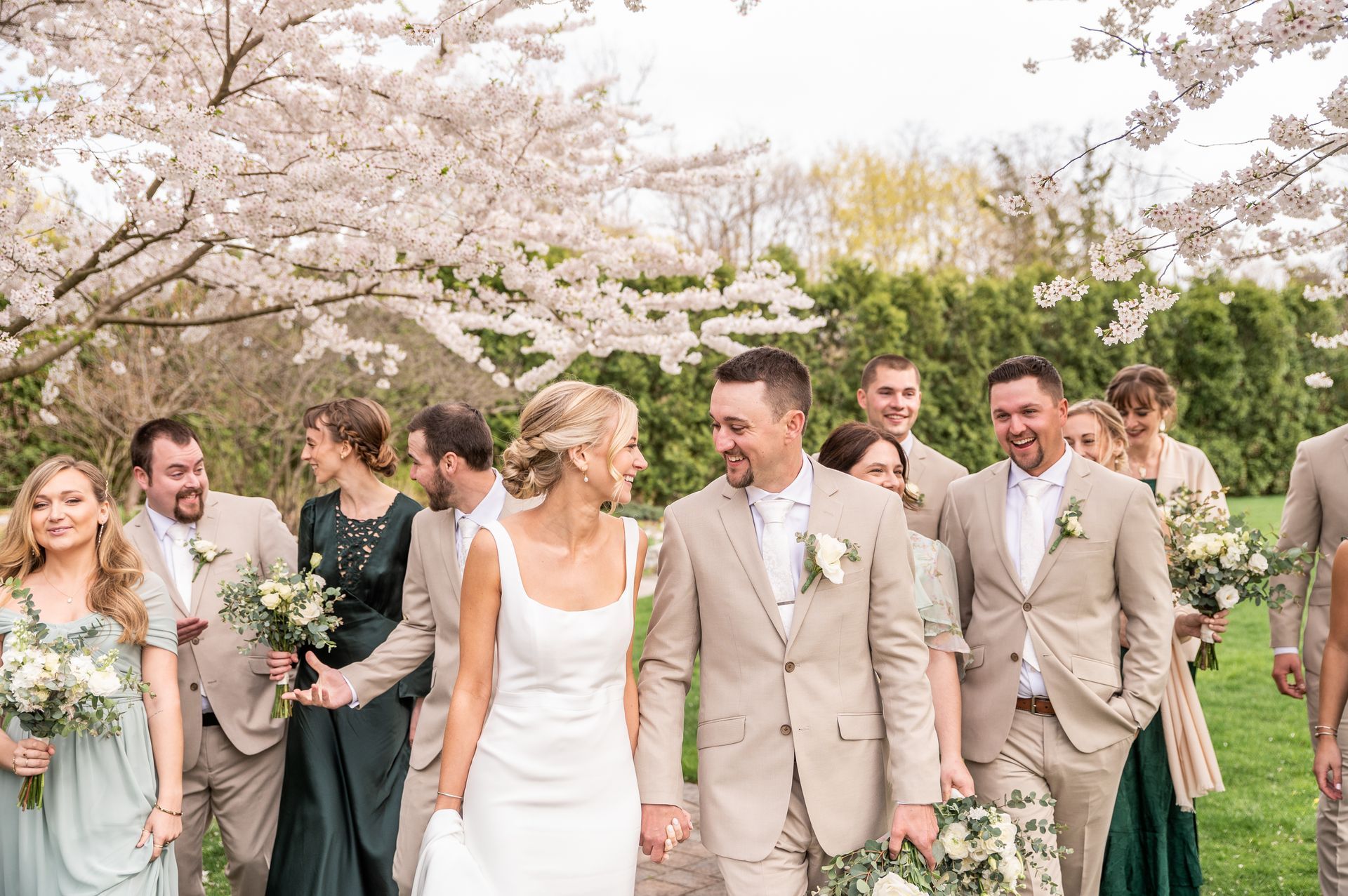 A bride and groom are walking with their wedding party.