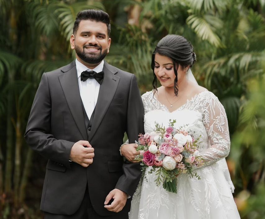 A bride and groom are posing for a picture on their wedding day.