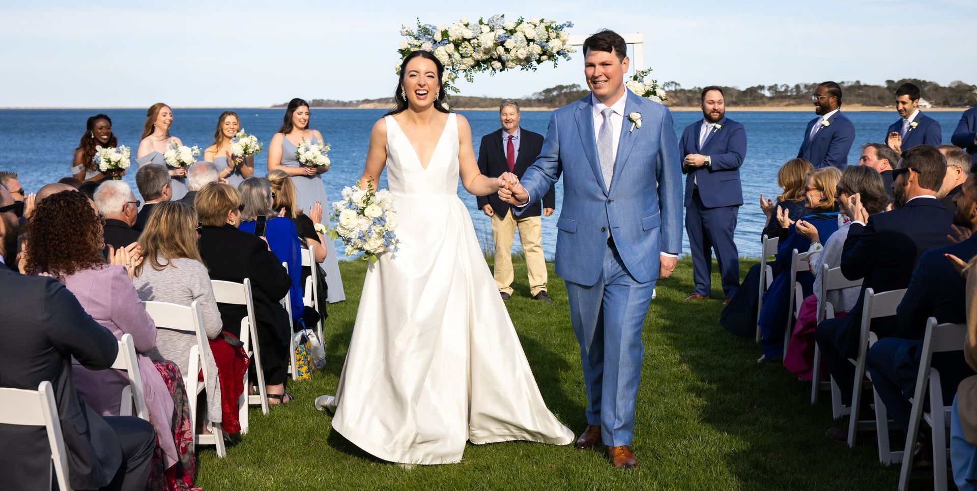 A bride and groom are walking down the aisle at their wedding ceremony.