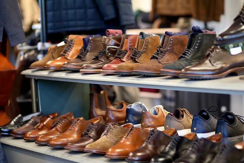 A row of shoes are lined up on a shelf in a store.