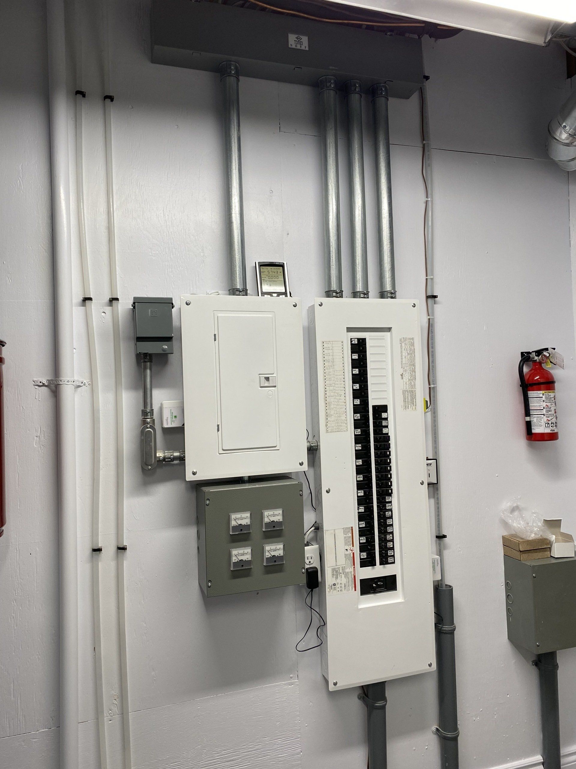 Il y a un extincteur sur le mur à côté d'un boîtier électrique.