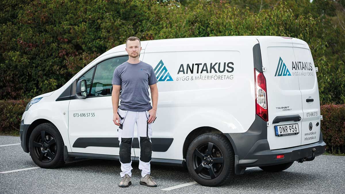 A man is standing in front of a white van.