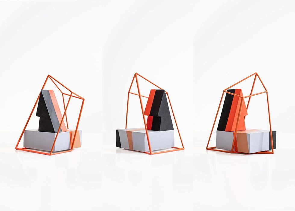 Drie abstracte sculpturen: grijze en oranje blokken, zwarte en oranje geometrische vormen en frames van koperdraad.
