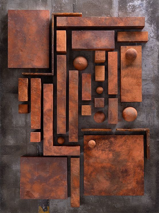 Abstracte sculptuur bestaande uit diverse baksteenachtige vormen in bruintinten, gemonteerd op een grijze, gestructureerde achtergrond.