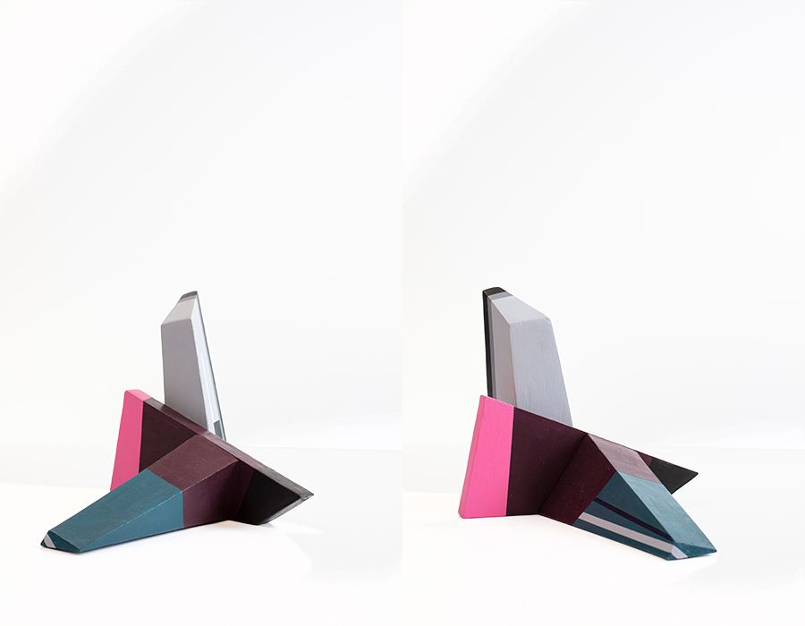 Sculpturaal kunstwerk, hoekige vormen, turquoise, roze, grijs en zwart op een witte achtergrond.
