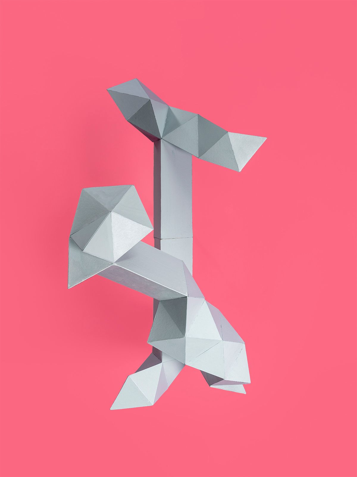 Abstracte geometrische sculptuur in grijs op een roze achtergrond.