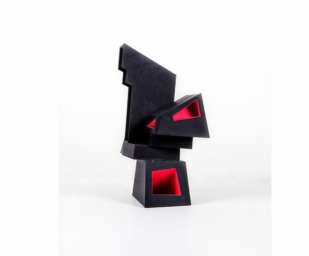 Abstracte zwarte sculptuur met rode accenten aan de binnenkant.