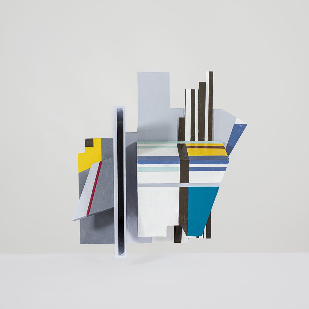 Abstracte geometrische sculptuur met kleurrijke vormen en lijnen tegen een lichte achtergrond.