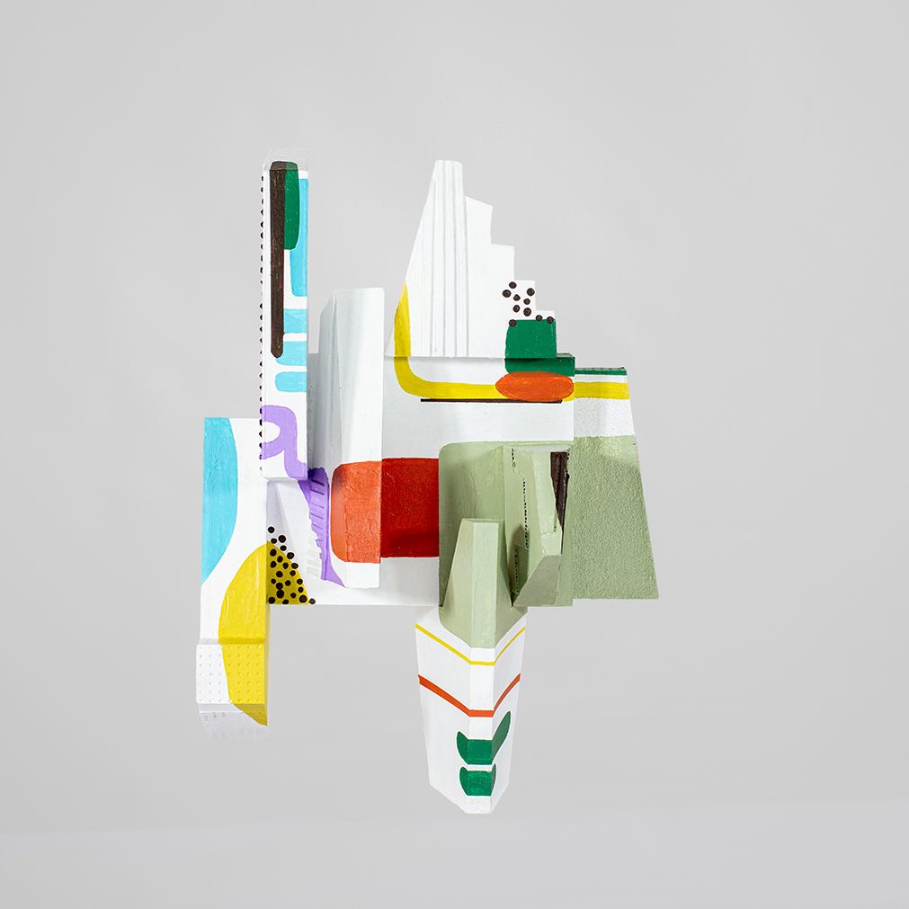 Abstracte, kleurrijke 3D houten sculptuur op een witte achtergrond. Bevat diverse geometrische vormen, geschilderd in heldere kleuren.