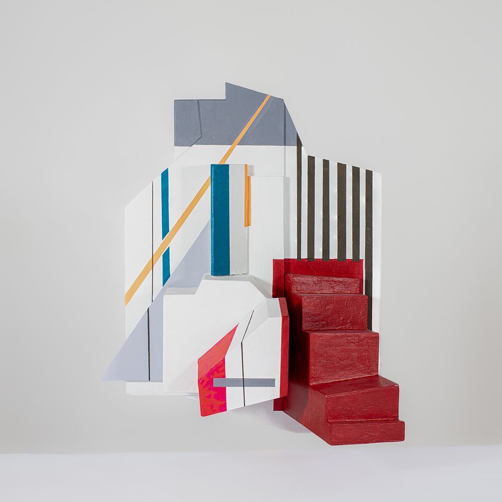Abstracte geometrische sculptuur met rode trappen, witte, grijze en zwarte vormen en kleurrijke lijnen.