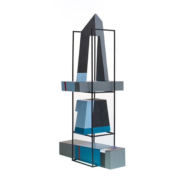 Abstracte sculptuur met geometrische vormen in grijs, blauw en zwart, ingelijst in een zwart metalen frame.