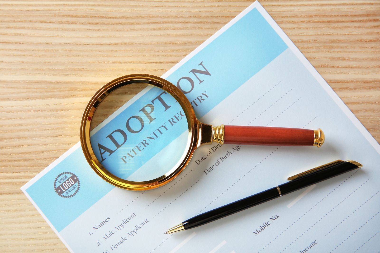 A magnifying glass is sitting on top of an adoption form