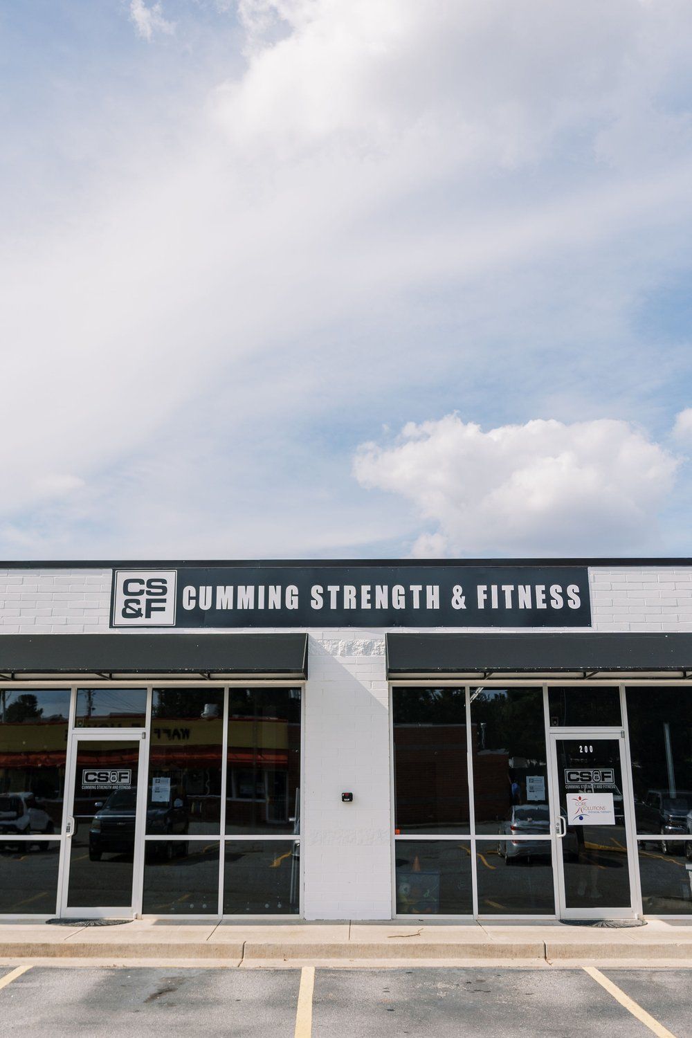 CrossFit Strength & Fitness storefront with glass windows and a cloudy sky above