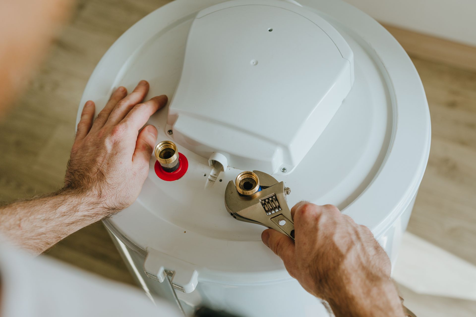 A man is repairing a water heater. A man is repairing a water heater.