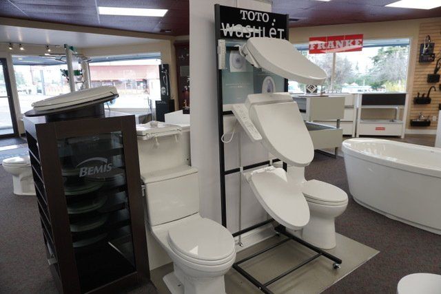 A display of toilets in a bathroom with a sign that says toto