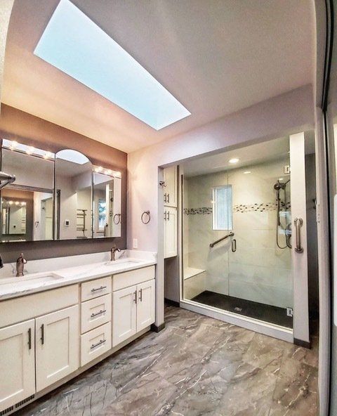 A bathroom with two sinks and a walk in shower