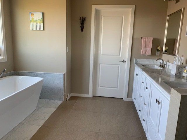 A bathroom with a bathtub and two sinks