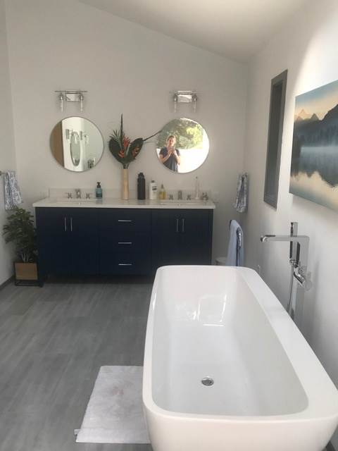 A bathroom with a bathtub and two mirrors