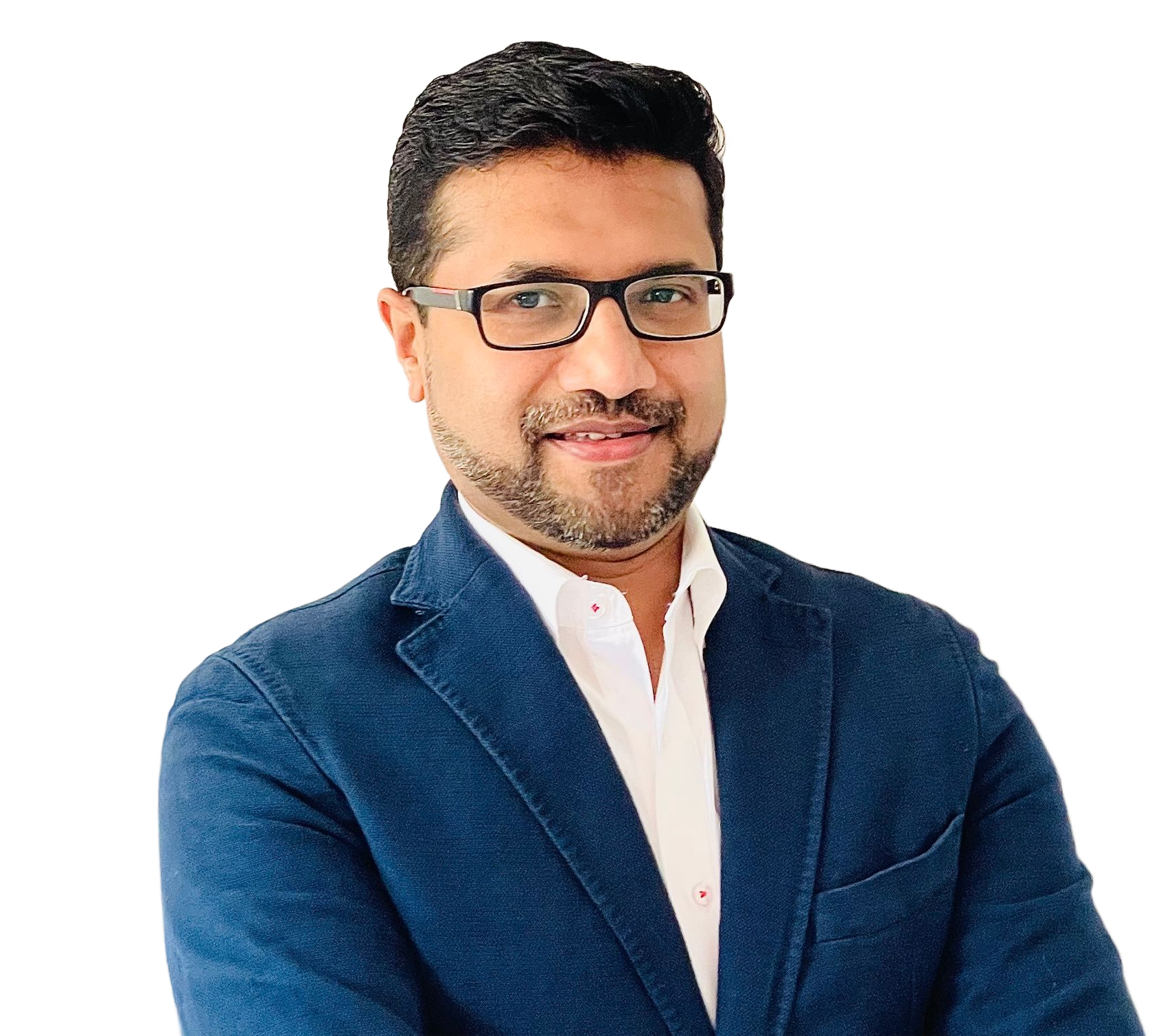 A man wearing glasses and a blue jacket is standing in front of a white wall.