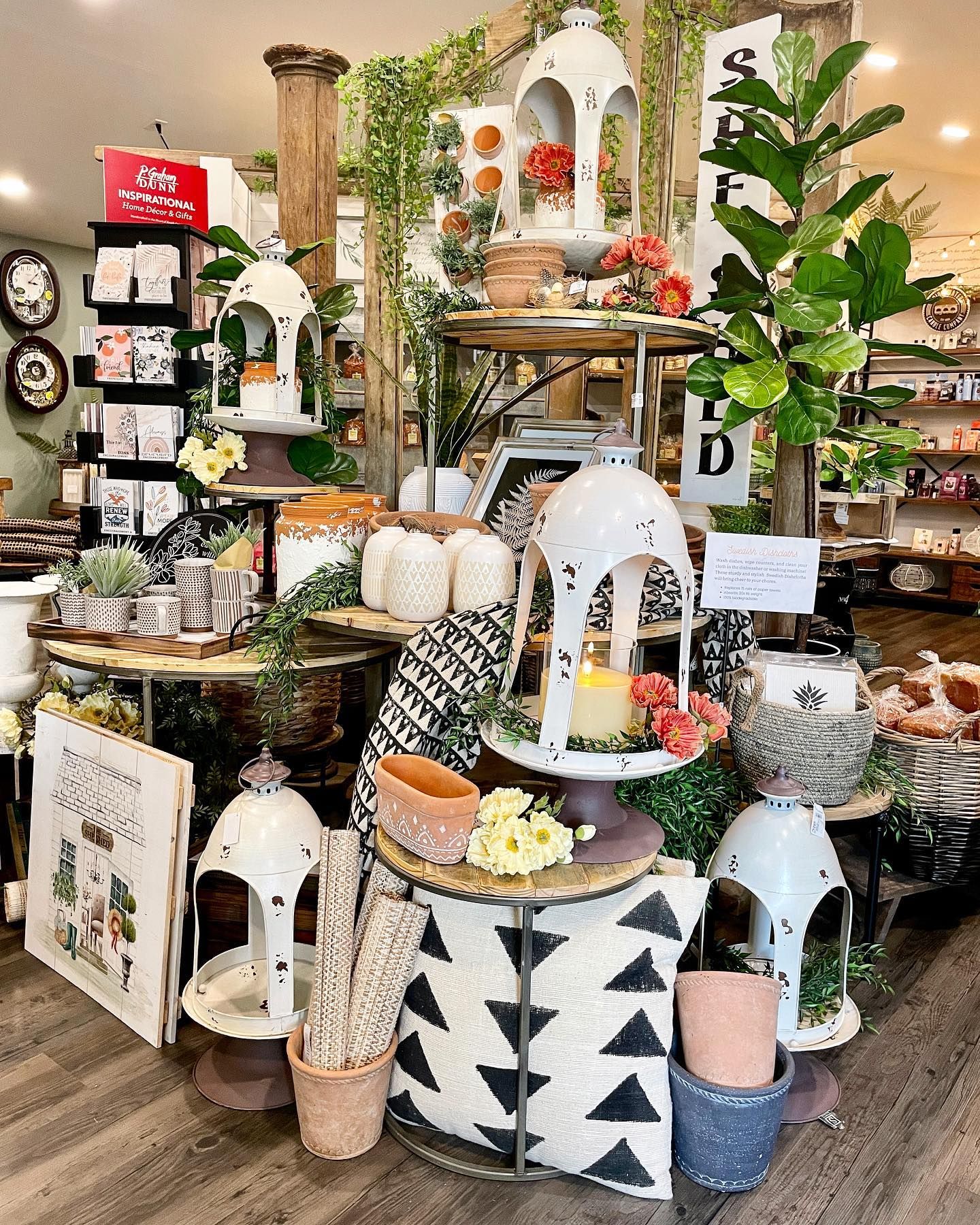 A retail display of lanterns, plants, and decor items in a store.