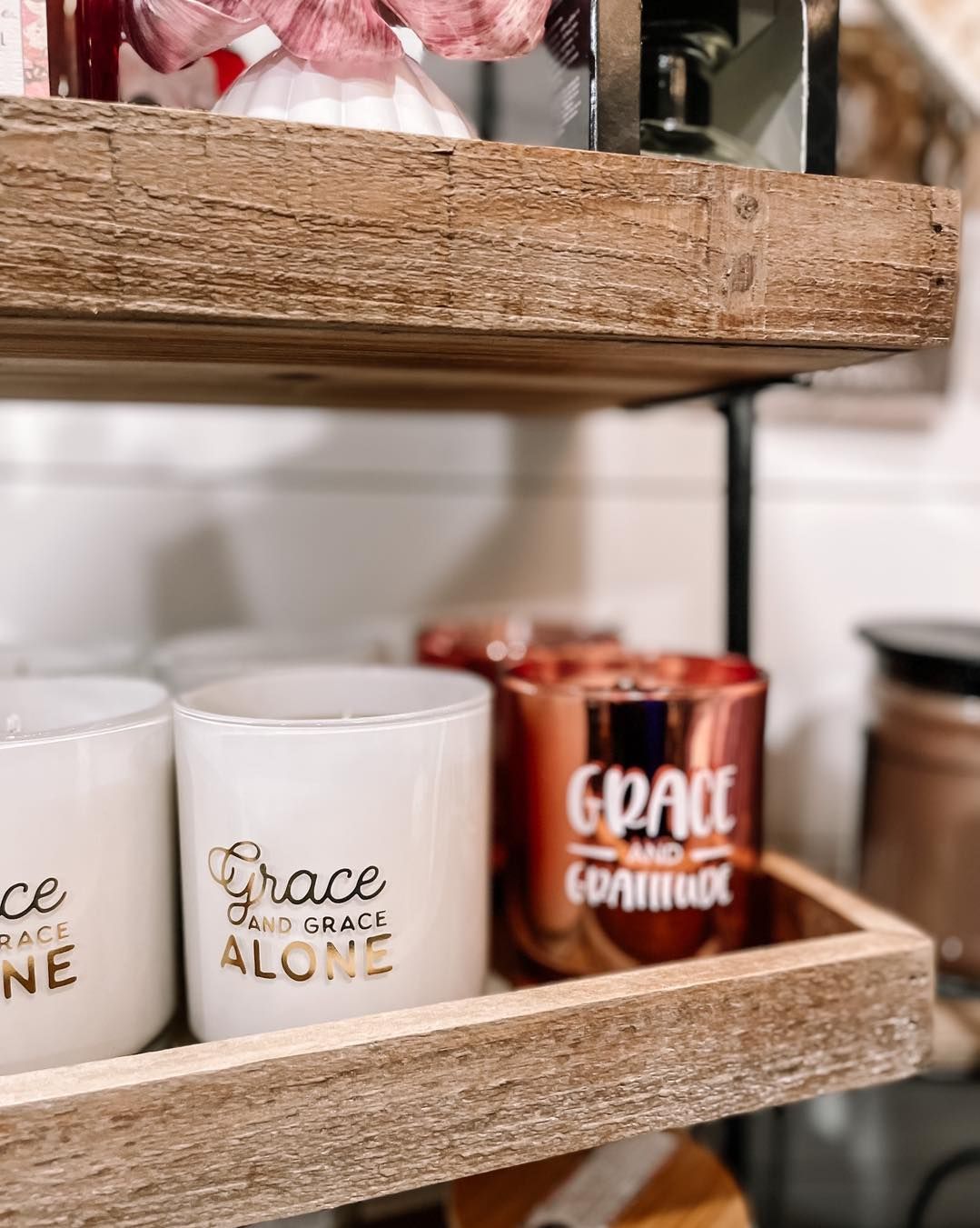 Shelves holding white and copper candles, some with 