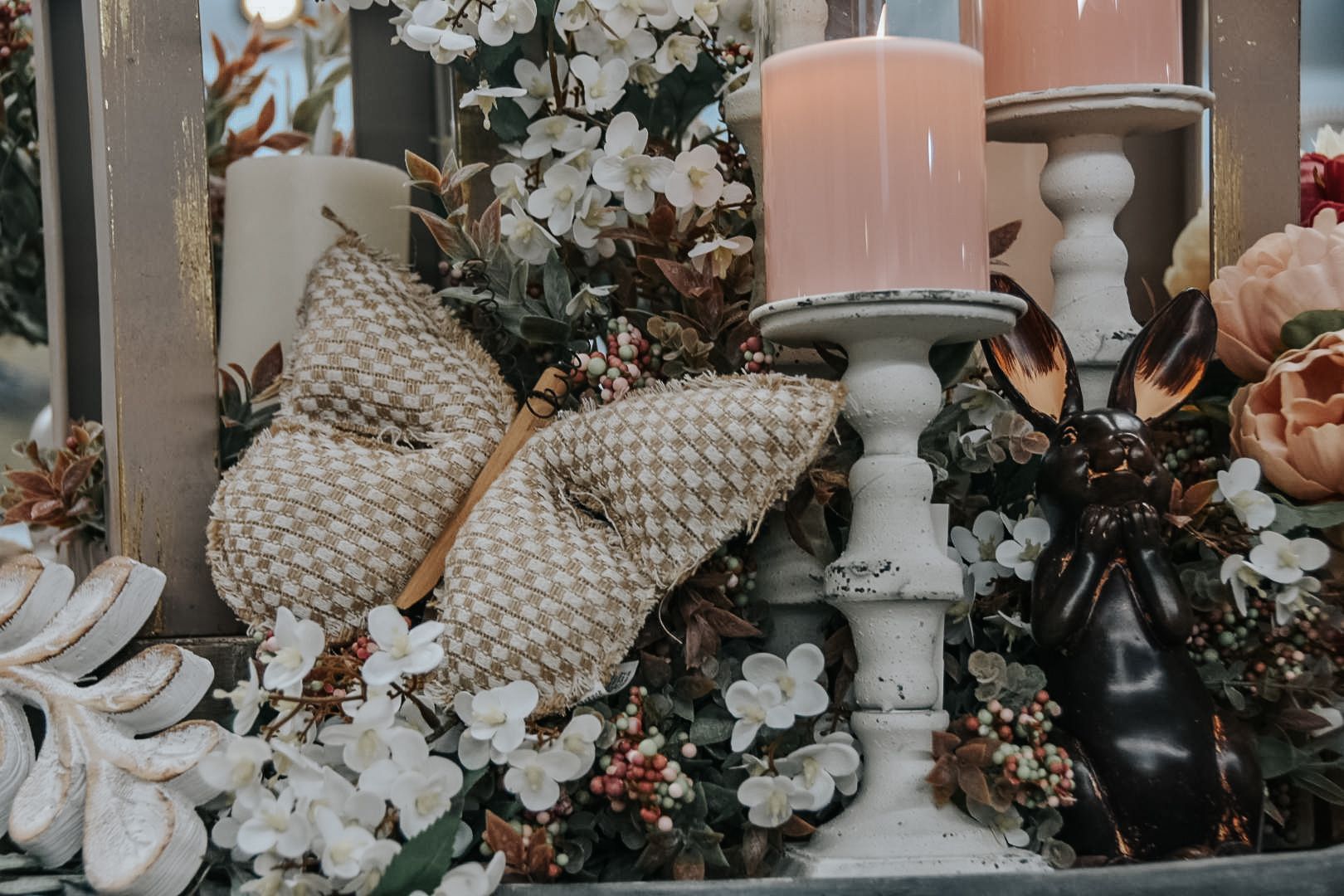 Floral arrangement with candles and a decorative butterfly.