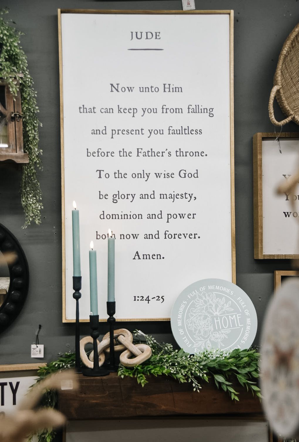 Sign with a poem, teal candles in black holder, and decorations on a shelf.