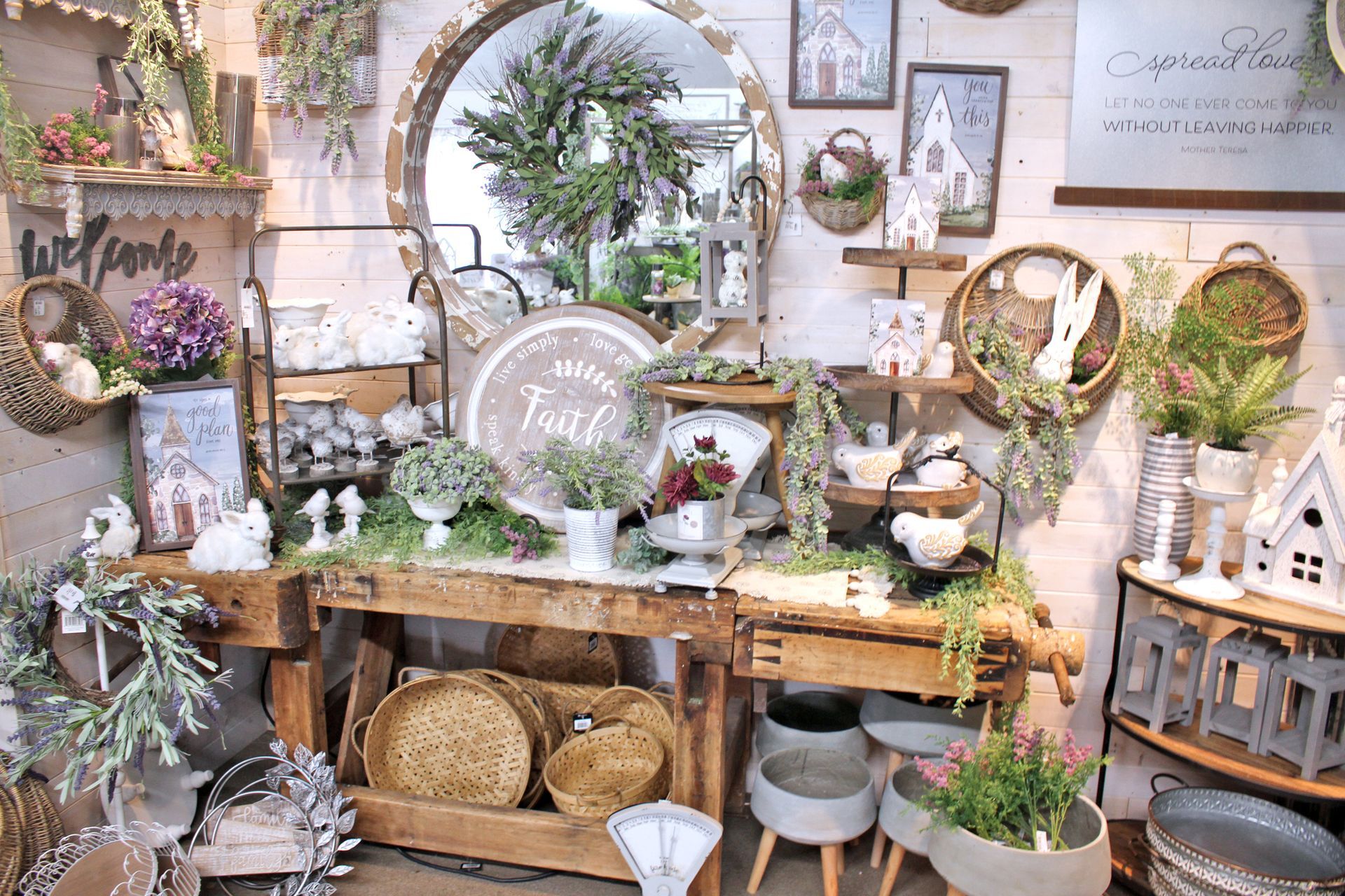 Shop display with rustic wooden shelves, decorated with plants, baskets, and decorative items.