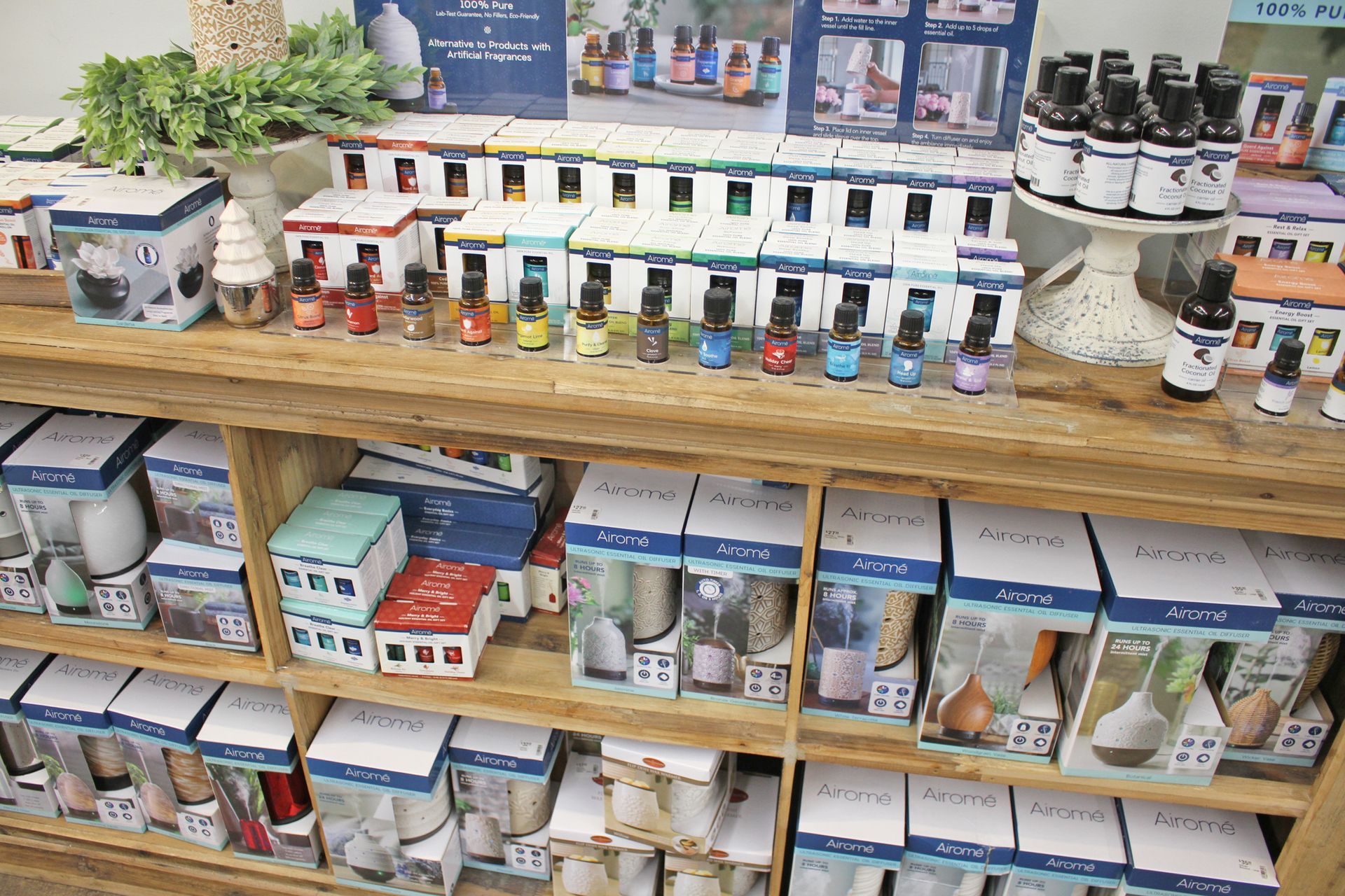 Wooden shelf display of essential oil bottles and packaged products.