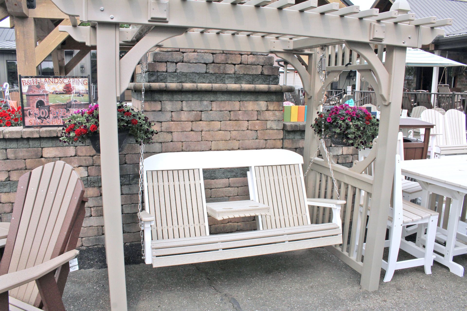 Beige pergola with swing and brick wall backdrop, outdoor setting.