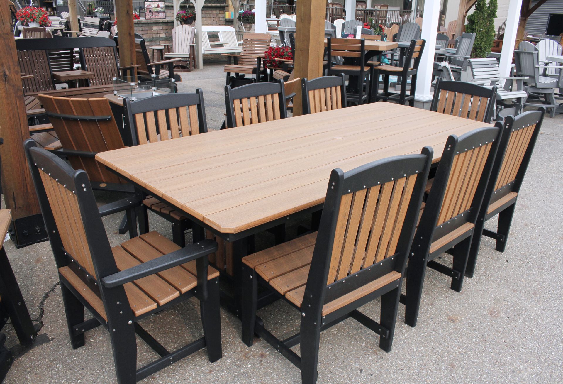 Outdoor dining set with brown and black chairs surrounding a large table on a stone surface.