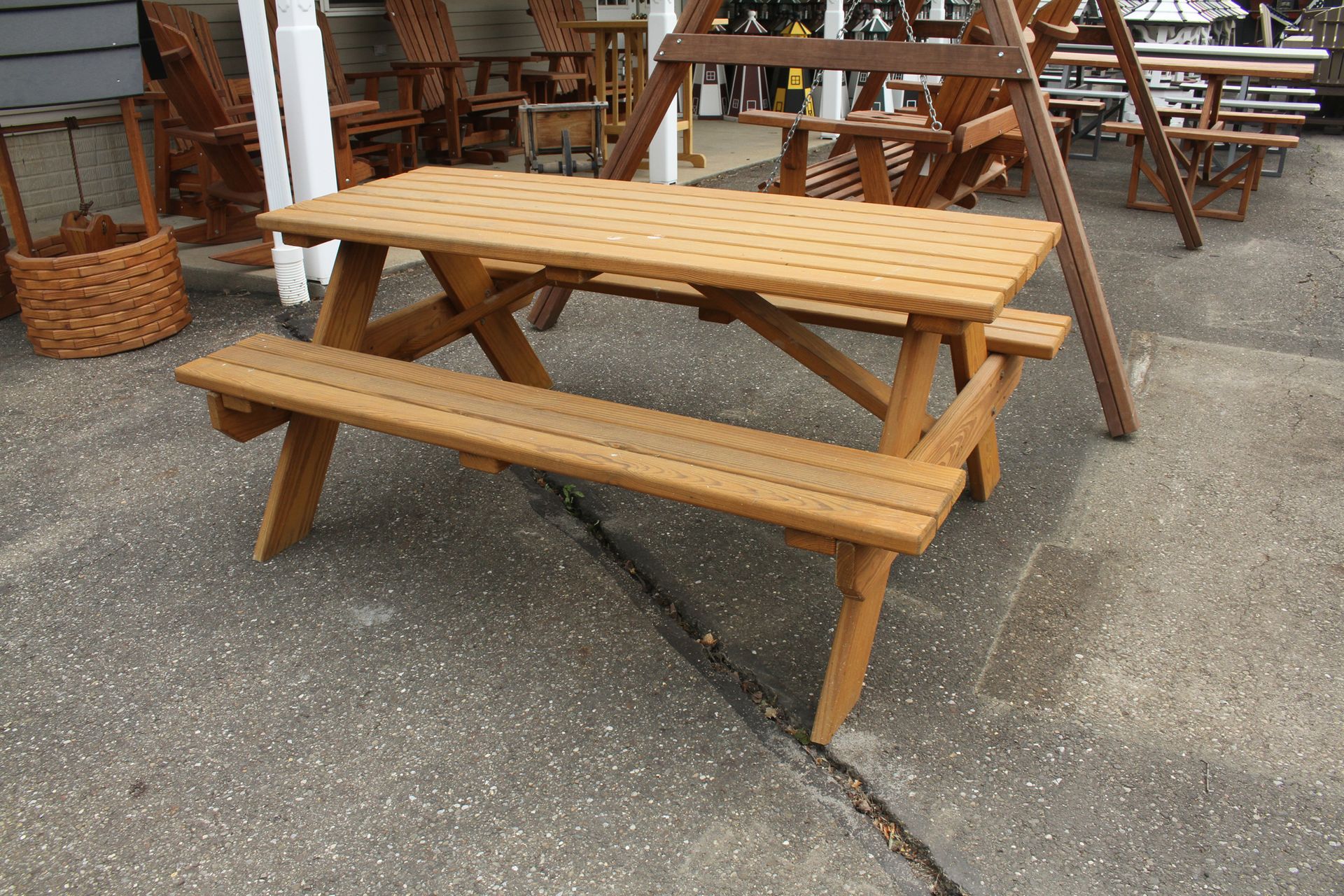 Brown picnic table with attached bench on a concrete surface, outdoor setting.