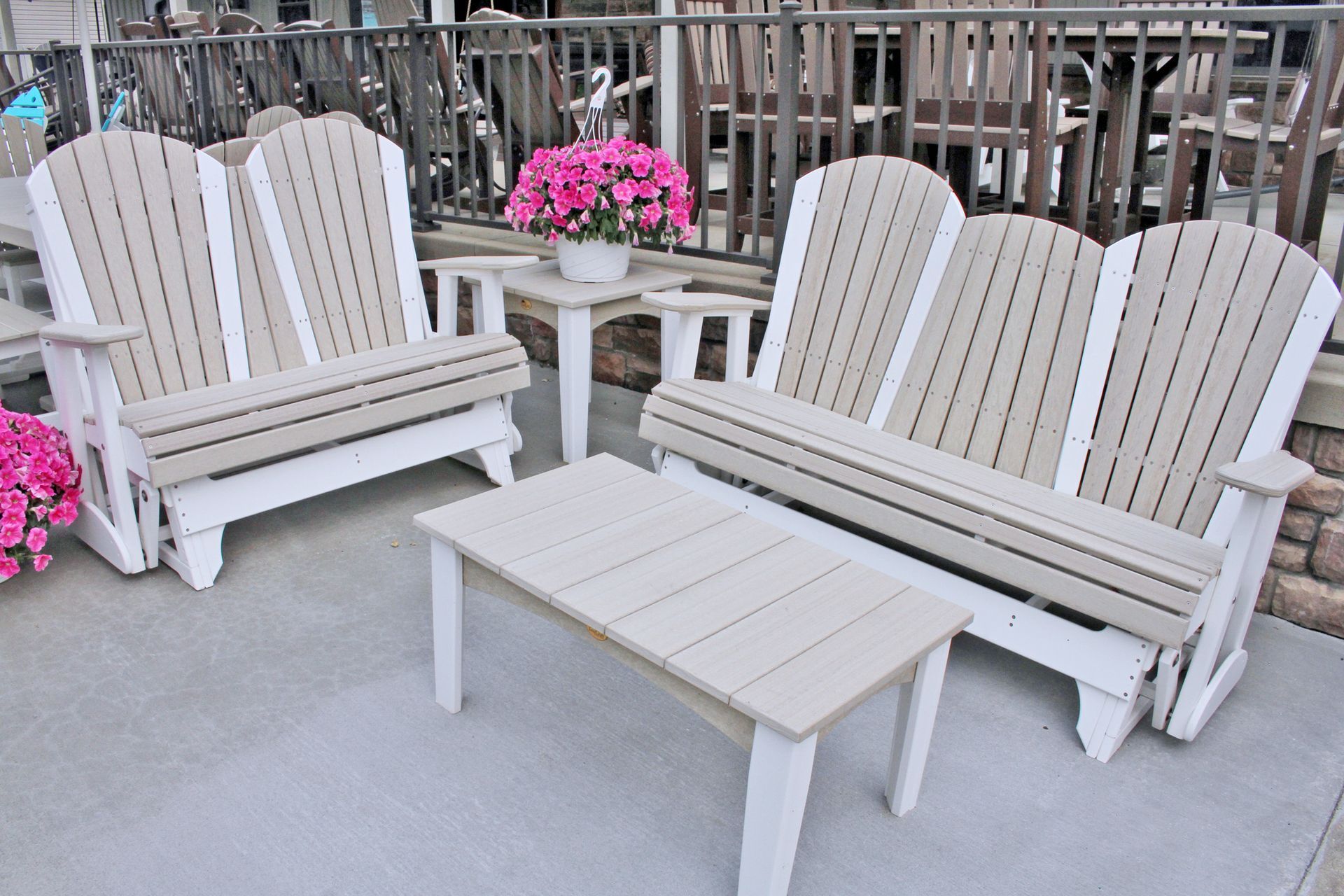 Outdoor furniture set: two double Adirondack chairs, small table, and side table, beige and white.