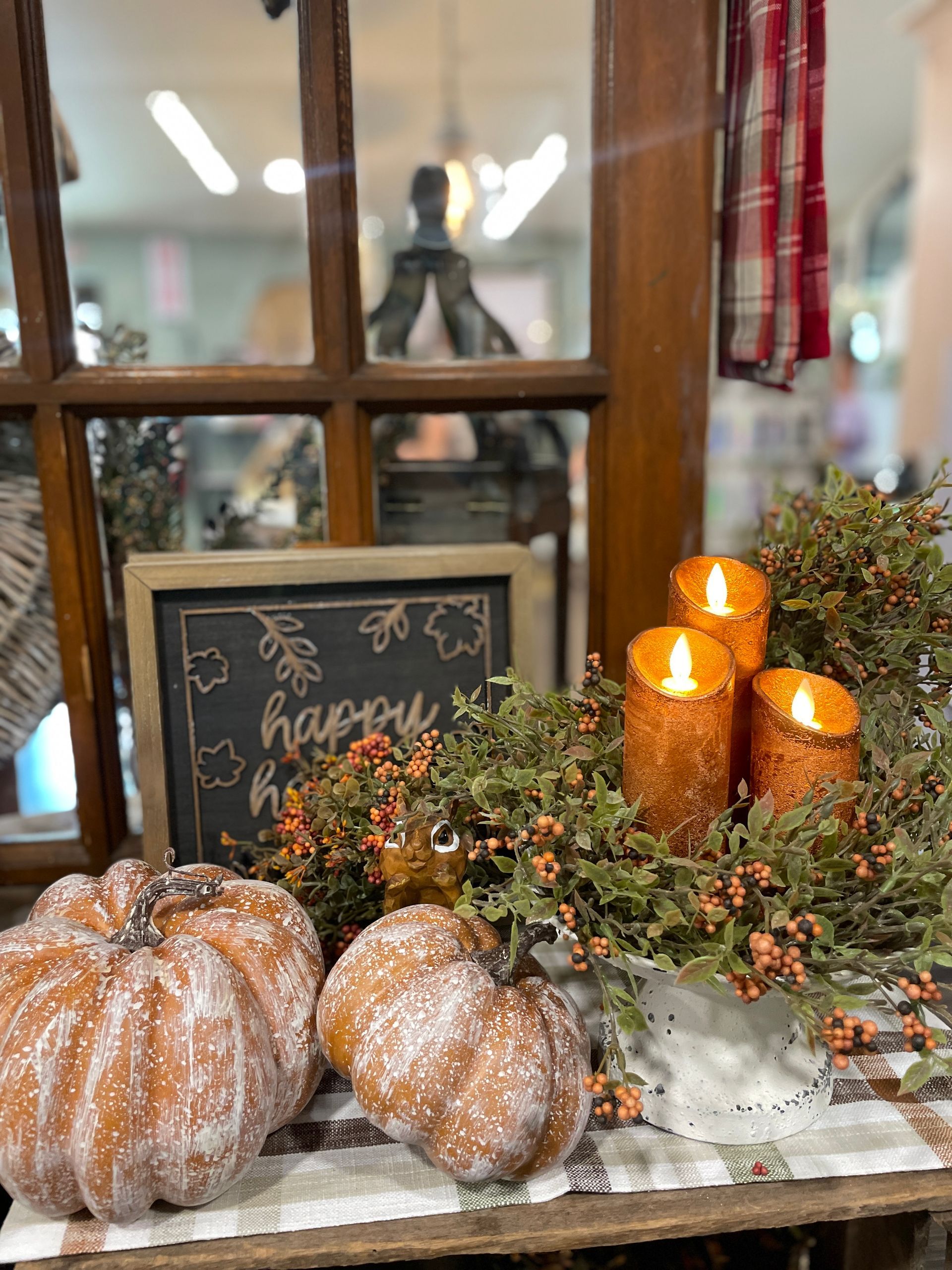 Fall decor: pumpkins, lit candles, greenery, and a 