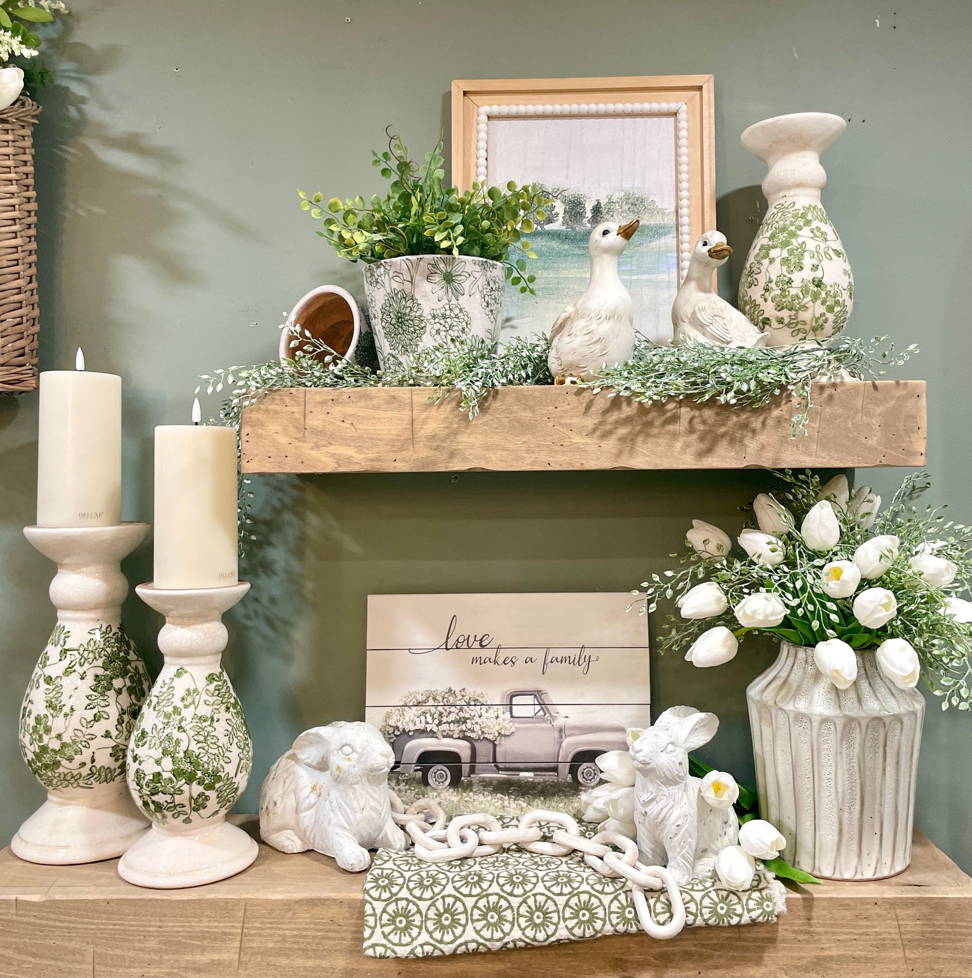 Shelf display with Easter decor: rabbits, tulips, geese, candles, and rustic accents.