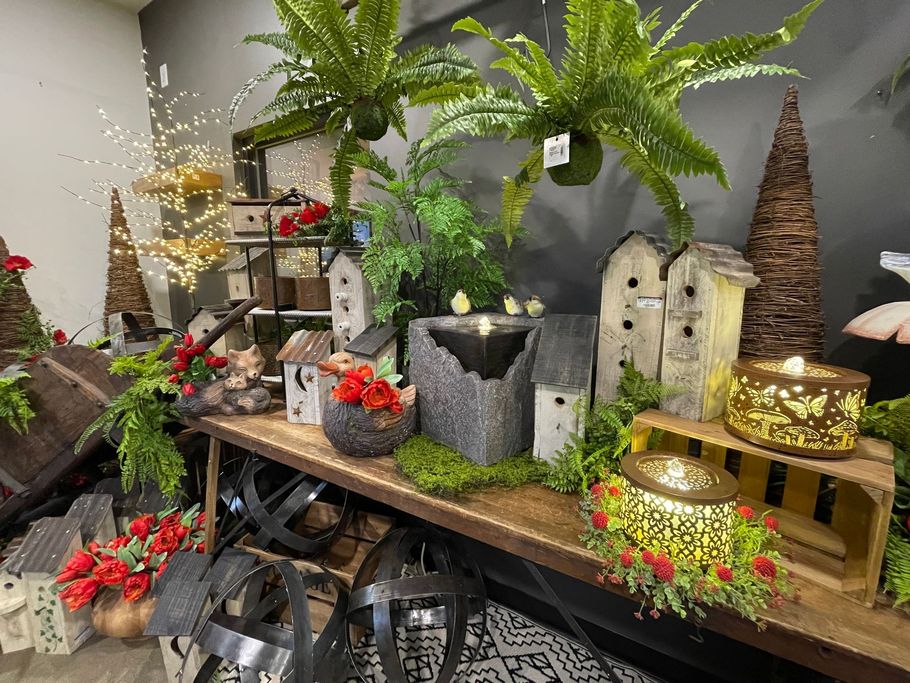 Display of garden decor including birdhouses, lanterns, and potted plants.