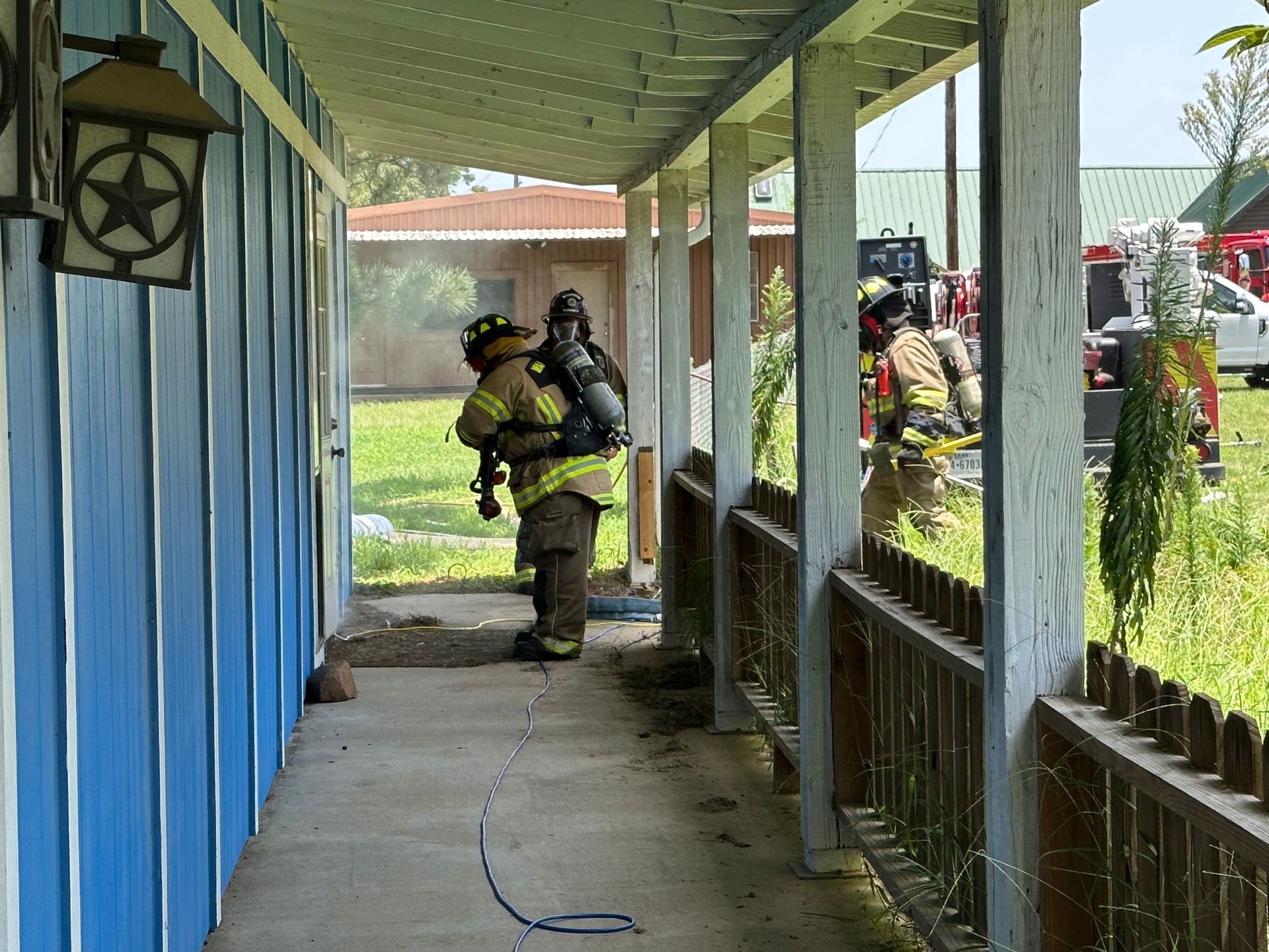 A group of firefighters are standing in a hallway.
