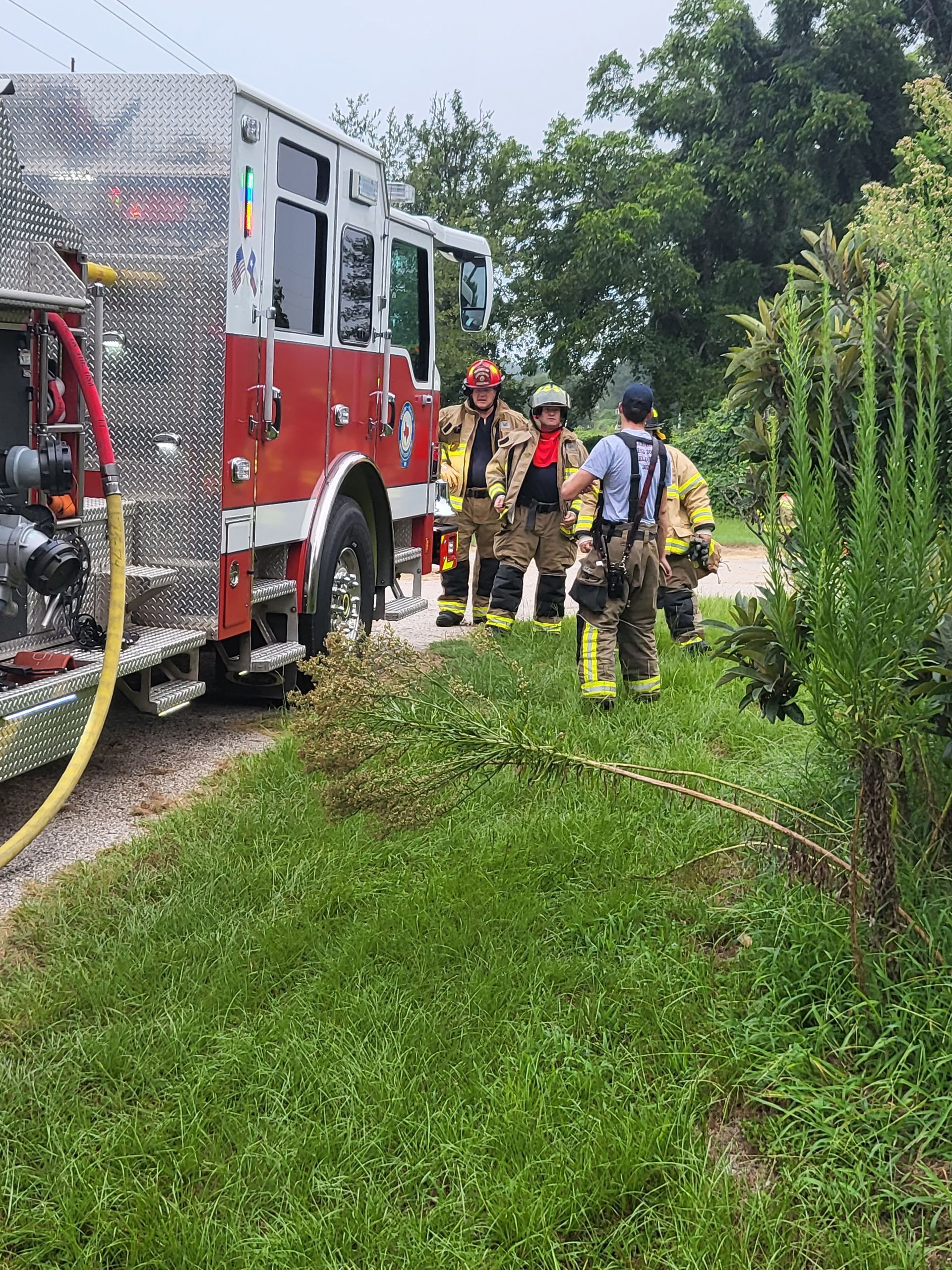 A group of firefighters are standing next to a fire truck.
