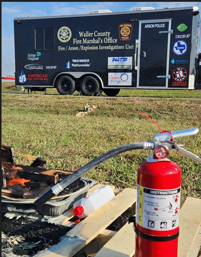 A fire extinguisher is sitting on a wooden pallet in front of a trailer.