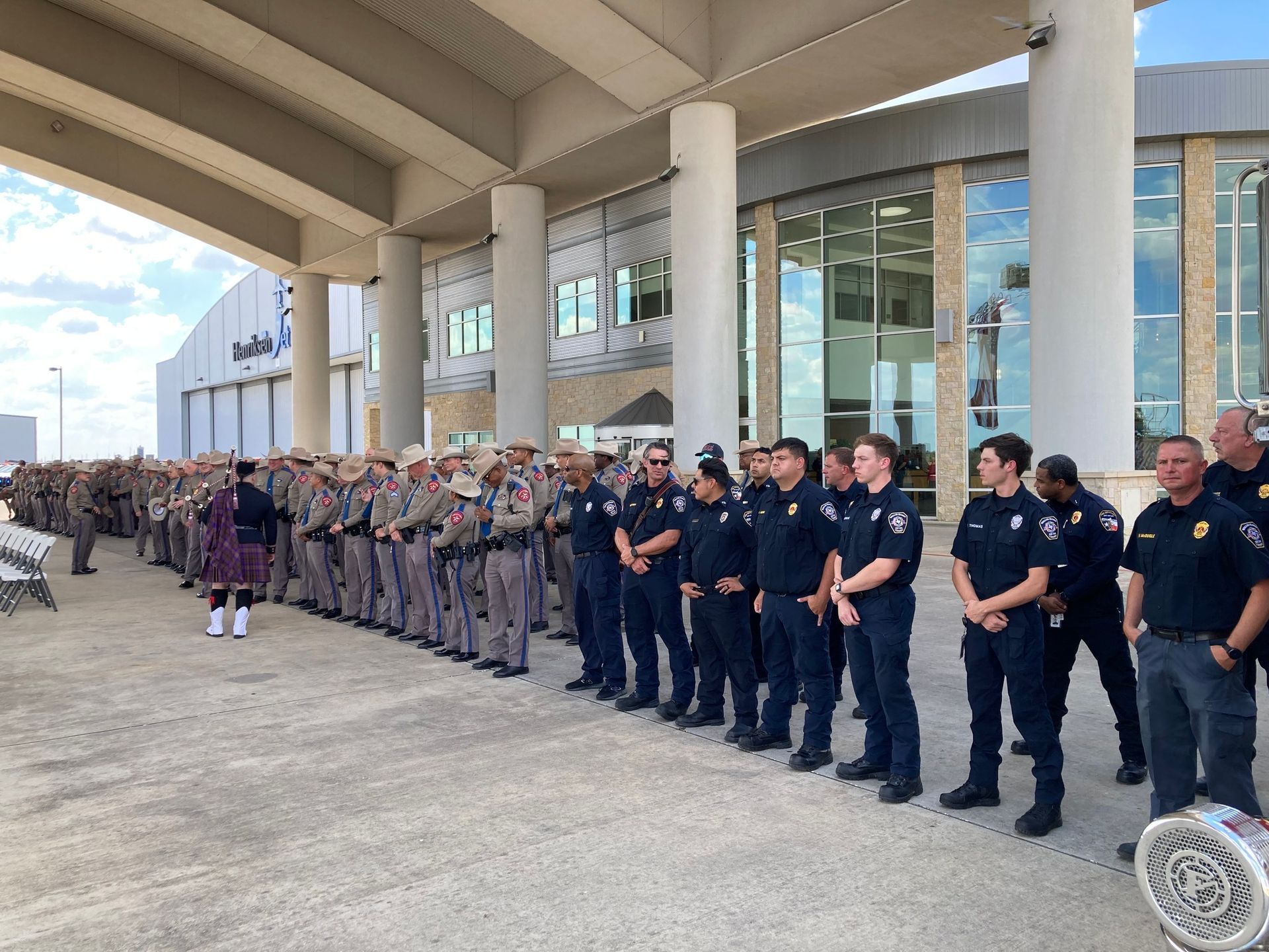 A large group of men in uniform are standing in front of a building.