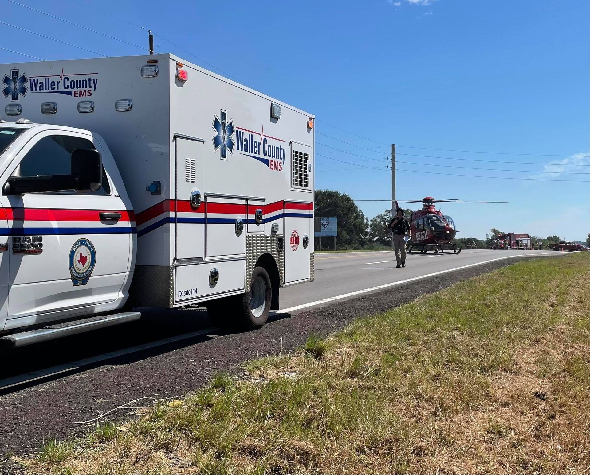An ambulance is parked on the side of the road next to a life flight helicopter.